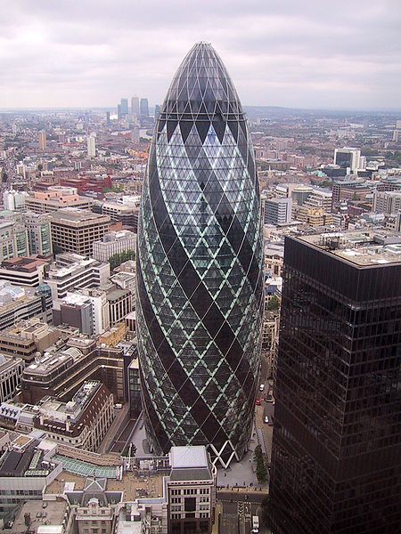 This is a photo of 30 St Mary Axe, which is also known as the Swiss Re Building or simply the Gherkin. This unique skyscraper is found in the main financial district of London, England. Standing 180&nbsp;metres (591&nbsp;ft) tall, the Gherkin opened in May 2004.